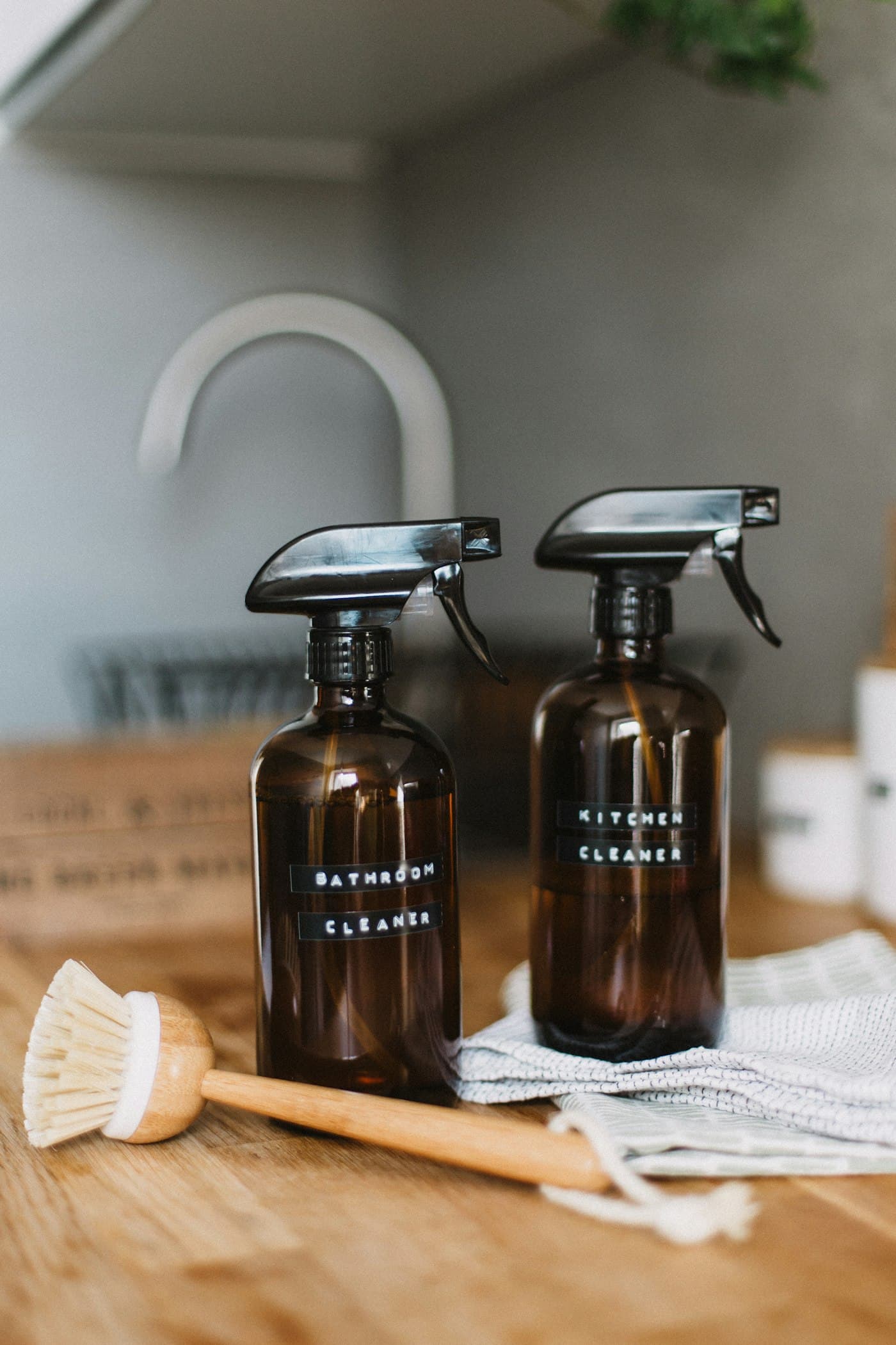 Bouteilles en verre ambré et brosse en bois sur un comptoir de cuisine