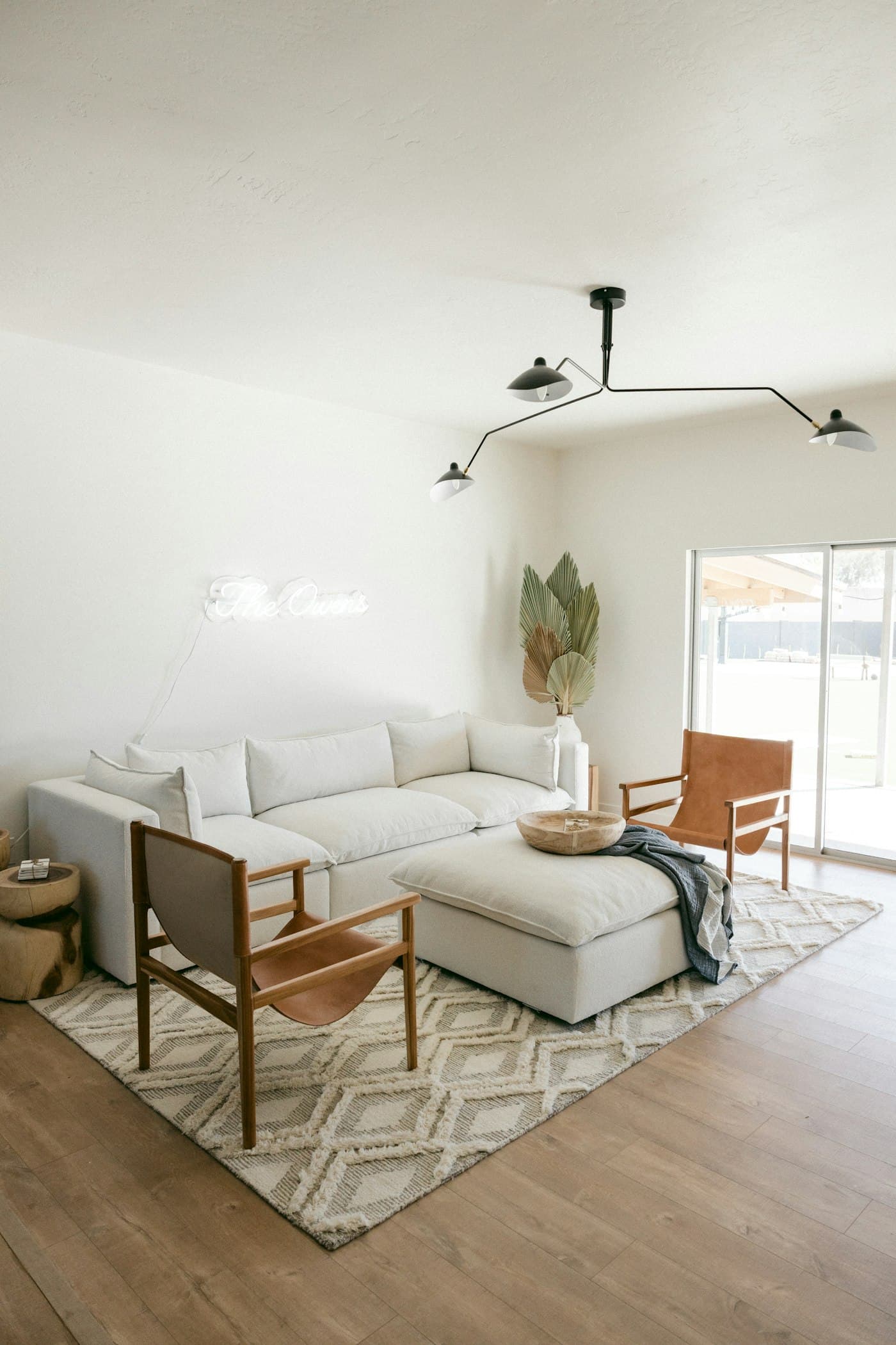 Salon en tons neutres avec grand tapis et planchers en bois chaud