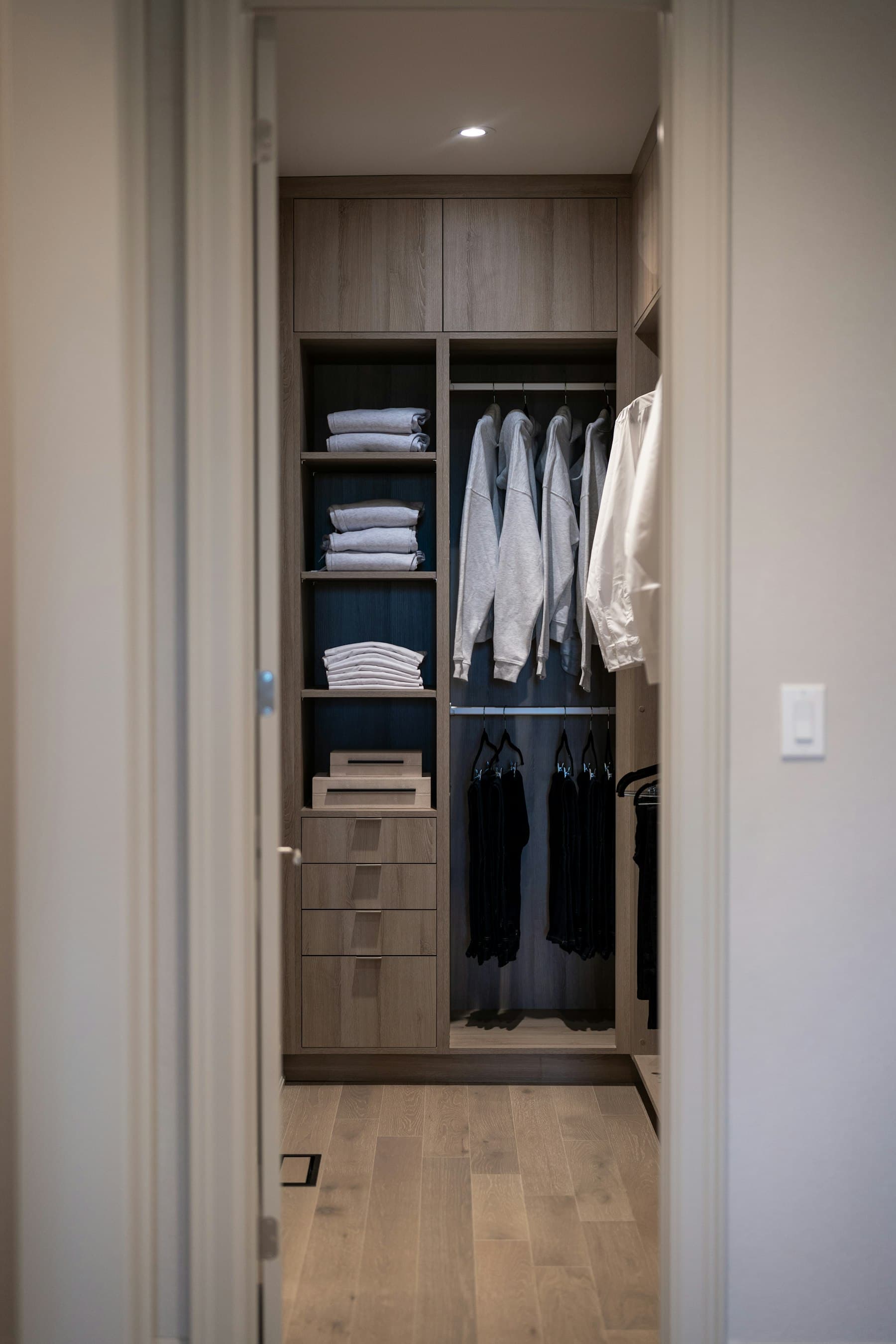 Walk-in organisé avec vêtements pliés et étagères en bois chaud